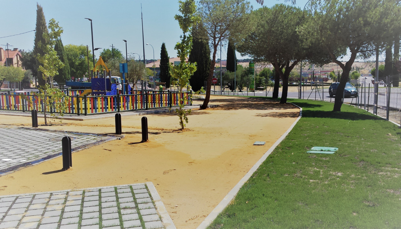 Parque infantil con juegos y árboles.
